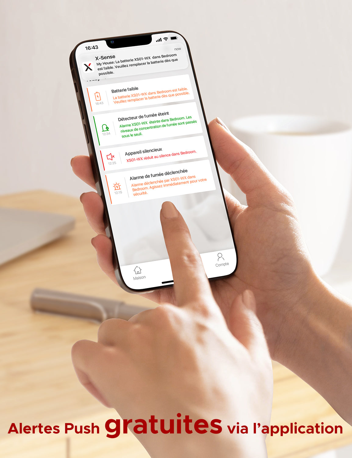 Un smartphone avec l'application Sécurité à domicile ouverte est tenu d'une main.